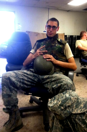 Doug sitting in military attire holding his helmet